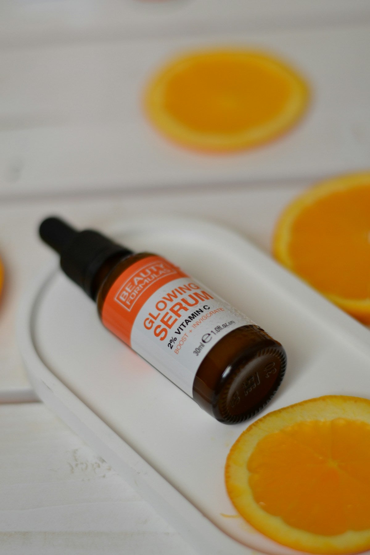 Frasco de sérum vitamina C sobre fondo naranja